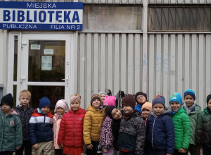 Dzieci stoją przed biblioteką