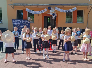 Dzieci z kapeluszami podczas śpiewania piosenki
