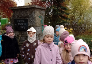 Dzieci stojąprzy pomniku Józefa Salwy