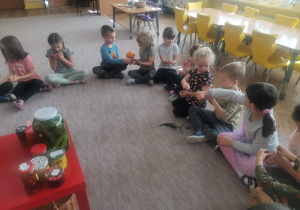 Dzieci oglądają i podają sobie warzywa