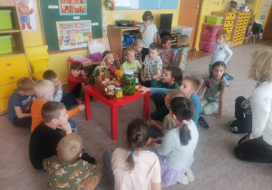 Dzieci oglądają przetwory zgromadzone na stoliku