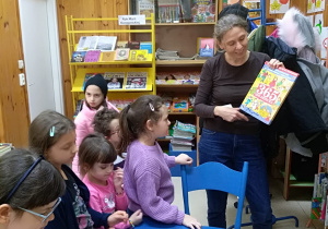 Pani bibliotekarka pokazuje dzieciom książkę