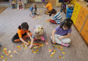 Dzieci z grupy VI układają puzzle z dyniami