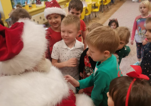 Dzieci z grupy VI stoją przed Mikołajem