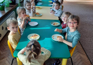 Dzieci z grupy III jedzą pizzę