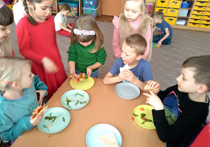 Dzieci z grupy VI przy stoliku jedzą swoje piadiny