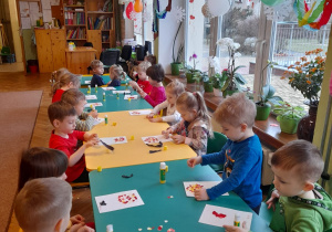 Dzieci z grupy III przy stolikach wykonują walentynkową pracę