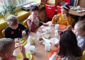 Kilkoro dzieci z grupy VI robią sobie kanapki z różnego pieczywa