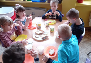 Kilkoro dzieci z grupy VI robią sobie kanapki z różnego pieczywa
