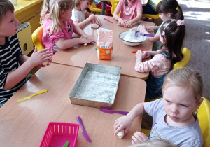 Dzieci z grupy VI przy stole podczas zabaw z masą solną