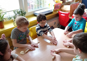 Dzieci z grupy VI przy stole podczas zabaw z masą solną