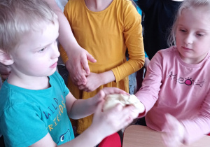 Troje dzieci trzyma ciasto chlebowe