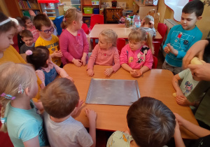 Dzieci przy stoliku formują bułeczki