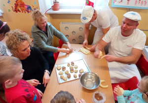Piekarze pokazują dzieciom, jak formować pieczywo z ciasto chlebowego