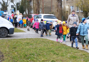 Dzieci idą w korowodzie na spacer