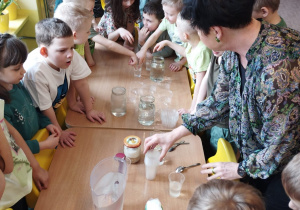 Dzieci z grupy VI próbują wodę z różnych kubeczków
