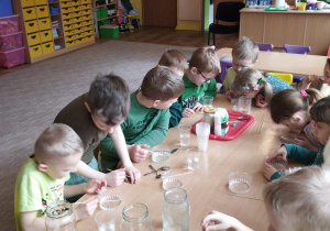 Dzieci z grupy VI wykonują przy stolikach różne doświadczenia z wodą