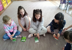 Jula, Bożenka, Daria i Tosia na dywanie ogladają torebki z nasionami