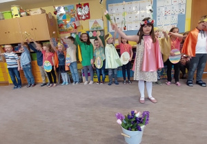 Tosia i dzieci machają kwiatami do piosenki