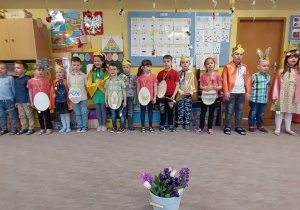 Dzieci ustawione w szeregu śpiewają piosenkę