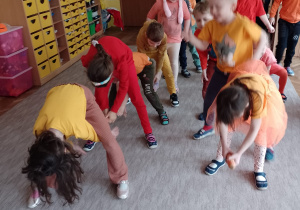 dzieci z grupy VI ustawione w dwu rzędach podają marchewkę między nogami
