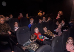 Dzieci z grupy II siedzą w sali kinowej