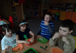 Laura, Maja Ch., Radek i Krzyś przy stoliku jedzą zielone kanapeczki