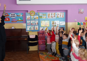 Dzieci naśladują ruchy pokazywane przez tancerkę
