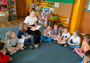 Dzieci słuchają książki czytanej przez Jagodę