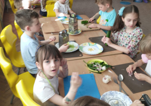 Kilkoro dzieci z grupy VI przy stole robią tzatziki
