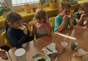Kilkoro dzieci z grupy VI przy stole degustują sos tzatziki