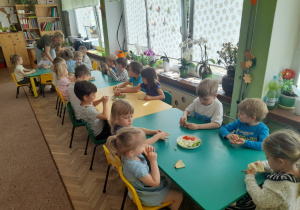 Dzieci z grupy III przy stole degustują chlebek pita