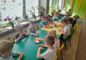 Dzieci z grupy III przy stole degustują chlebek pita