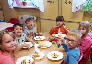 Dzieci z grupy V przy śniadaniu degustują różne produkty greckie