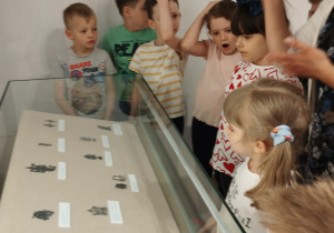 Dzieci stoją przy gablocie z eksponatami