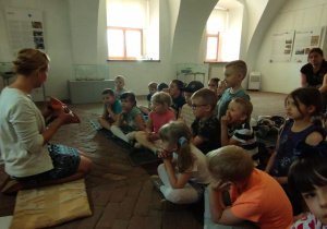 Pani Justyna pokazuje dzieciom eksponat