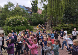 Dzieci ustawione w rozsypce tańczą do muzyki