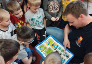 Pan Michał pokazuje dzieciom z grupy V zestaw klocków