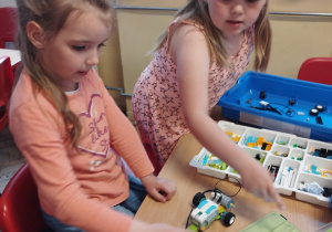 Dwie dziewczynki z grupy V przy stoliku budują z klocków