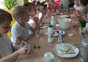 Dzieci z grupy VI przy stole robią deser