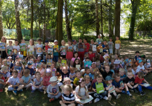 Wspólne zdjęcie dzieci z całego przedszkola z książkami w ogrodzie