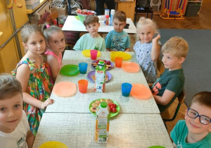 Grupa dzieci siedzi przy stole