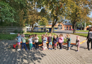 Dzieci stoją w parach na chodniku w pobliżu dworca