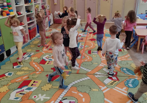 Dzieci chodzą po sali z listkami na głowie