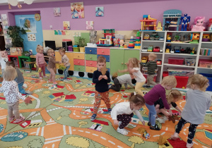Dzieci podnoszą z dywanu listki