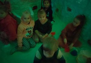 Kilkoro dzieci siedzi w grocie solnej