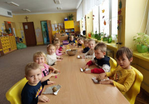 Dzieci z grupy Pszczółki przy stoliku z ziemniakami