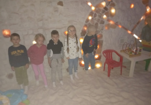 Pięcioro dzieci stoi przy solnej ścianie