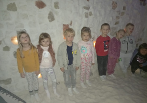 Kilkoro dzieci stoi przy solnej ścianie