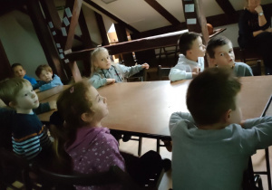 Dzieci siedzą przy stolikach podczas zajęć w muzeum